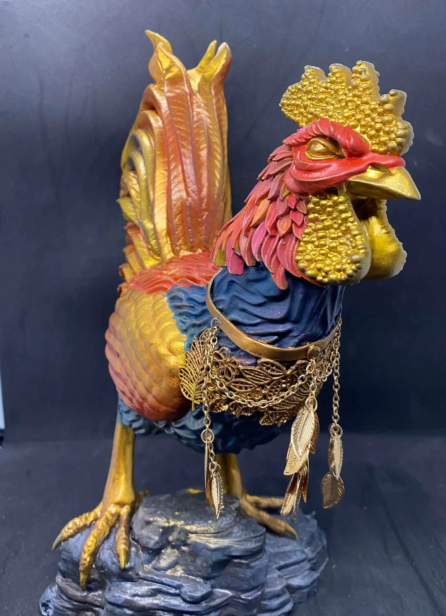 Close-up of the Sarimanok sculpture's vividly painted plumage and gold-adorned crest