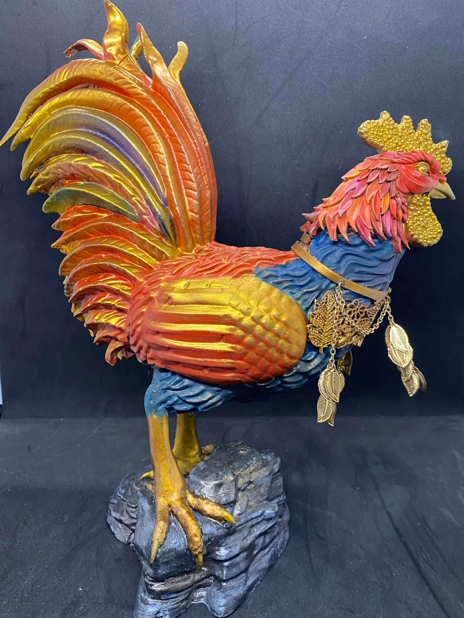 Side profile of the Sarimanok resin sculpture showing its sculpted feather detail and woodcraft-inspired headpiece