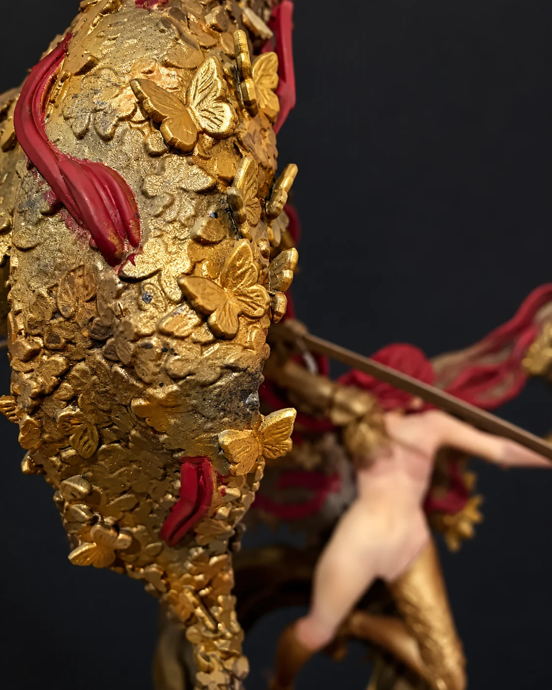 Close-up of the gold butterfly wing with Malenia in the background